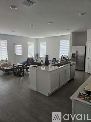 A kitchen with white cabinets and a wooden floor.