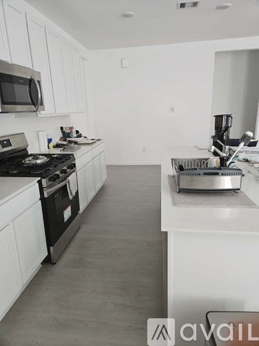 A kitchen with white cabinets and a black stove top.