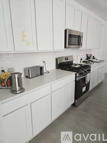 A kitchen with white cabinets and a black stove top.