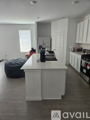 A kitchen with white cabinets and a white island.