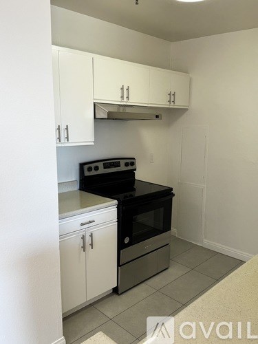 A kitchen with white cabinets and a black stove top oven.