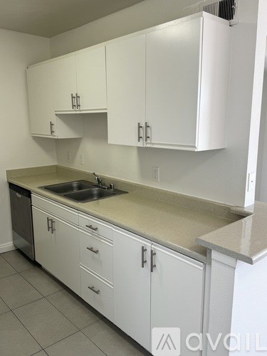 A kitchen with white cabinets and a sink.