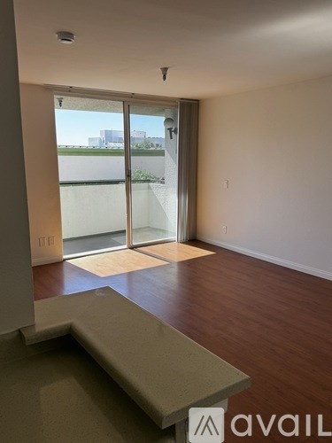 A room with a sliding glass door leading to a balcony.