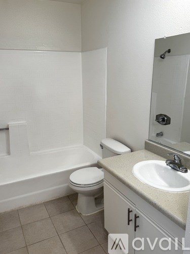 A bathroom with a toilet, sink, and mirror.