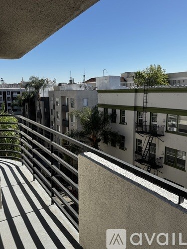 A view of a balcony with a metal railing and a building in the background.