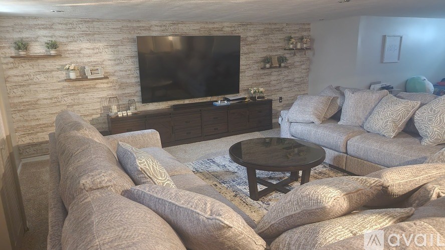 A living room with a stone wall and a flat screen TV.