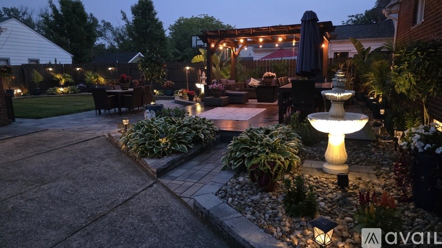 A garden with a fountain and a patio area.