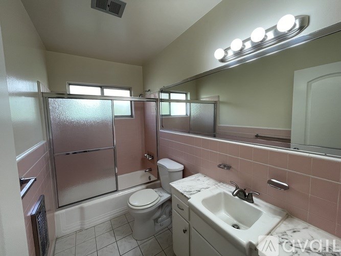 A bathroom with a toilet, sink, and shower.