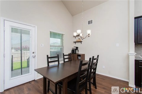 A dining room with a wooden table and chairs.