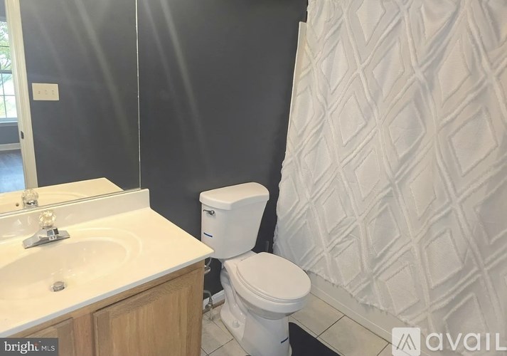 A white toilet sits next to a sink in a bathroom.