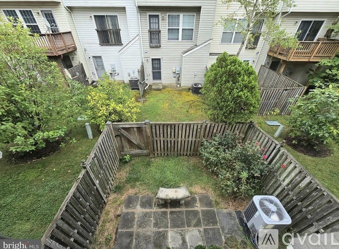 A small backyard with a patio and a fence.