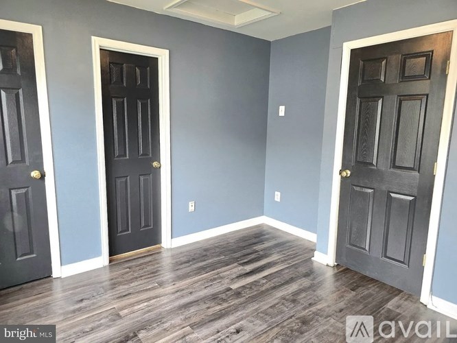 A room with two doors and a wooden floor.