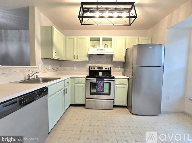 A kitchen with a stove top oven and a refrigerator.
