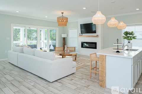 A living room with a white couch and a fireplace.