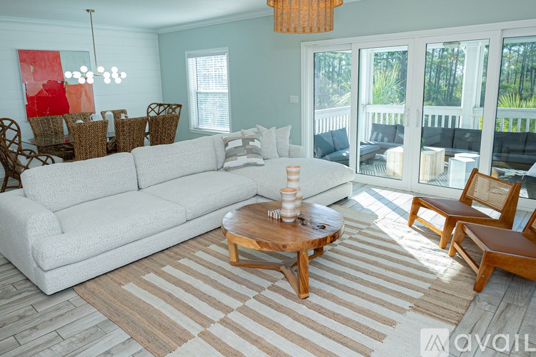 A living room with a white couch, wooden coffee table, and striped rug.