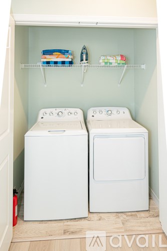 Two white front loading washing machines in a laundry room.