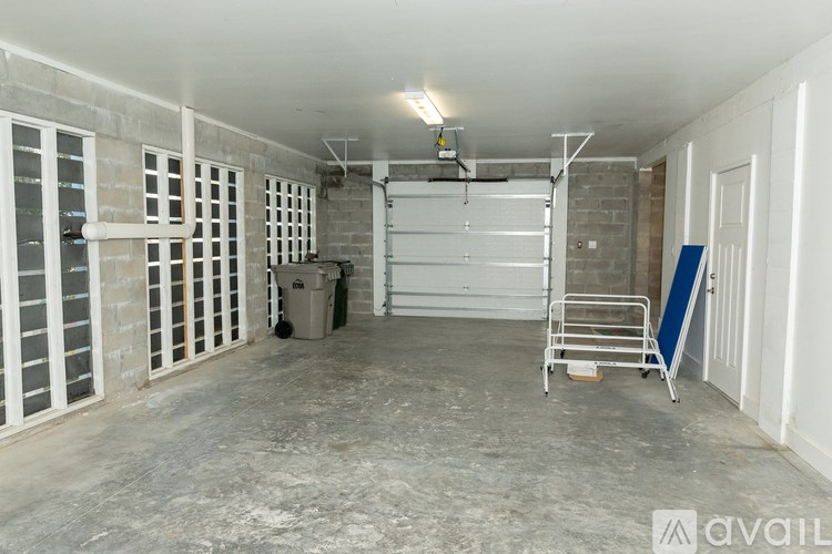 A large empty garage with a white ceiling and a white door.
