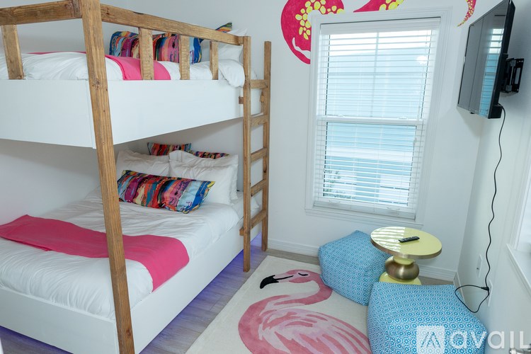 A room with a bunk bed and a small table.