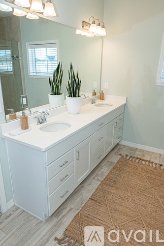 A bathroom with a white vanity and a mirror.