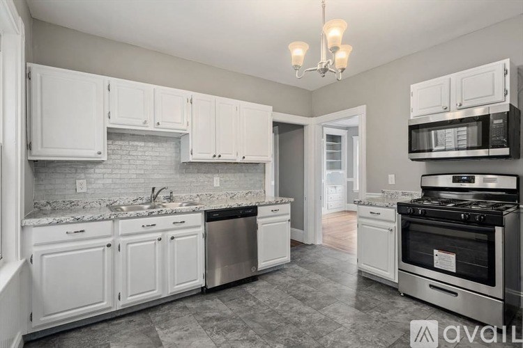 A kitchen with white cabinets and a black stove top oven.