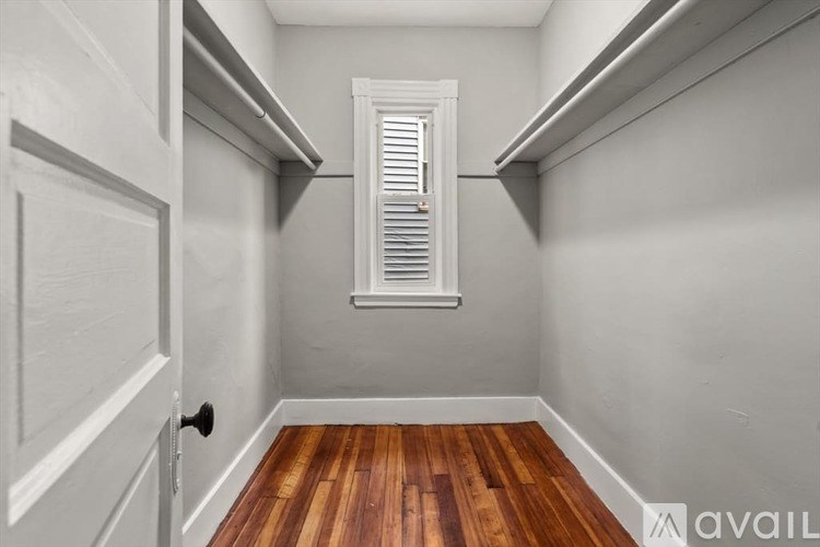 A hallway with a wooden floor and white walls.
