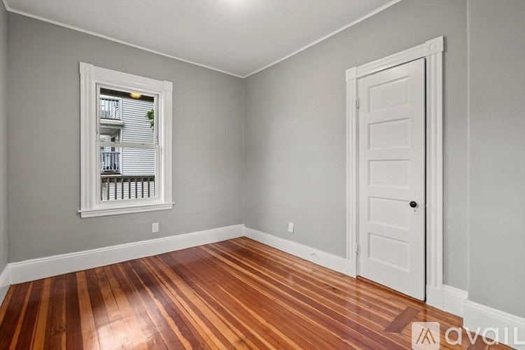 A room with a wooden floor and a white door.