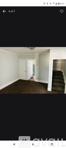 A room with white walls and a brown carpet.