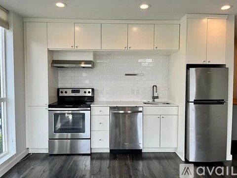 A modern kitchen with stainless steel appliances and white cabinetry.