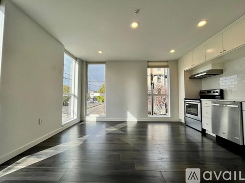 A spacious kitchen with black flooring and white cabinetry.