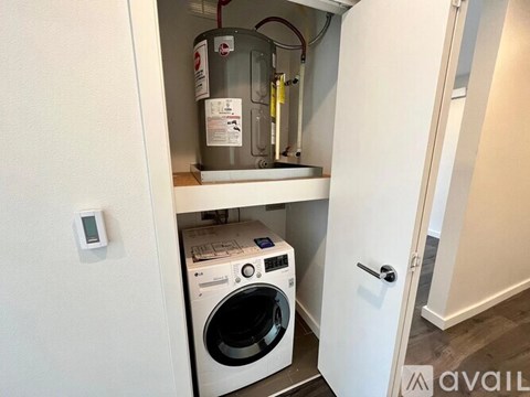 A washing machine is installed in a small alcove.
