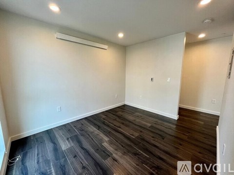A room with wooden flooring and white walls.