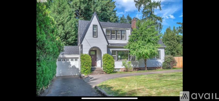 A house with a grey front yard and a white fence.