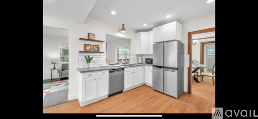 A kitchen with white cabinets and a refrigerator is available for rent.