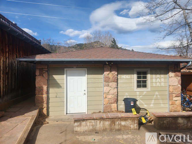 A small building with a white door and a sign that says "MENU BAR" on the window.