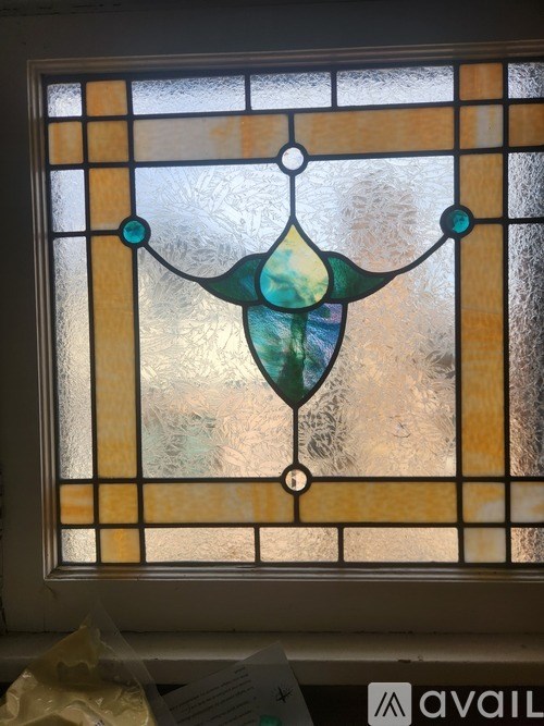 A stained glass window with a diamond shaped piece of glass in the center.