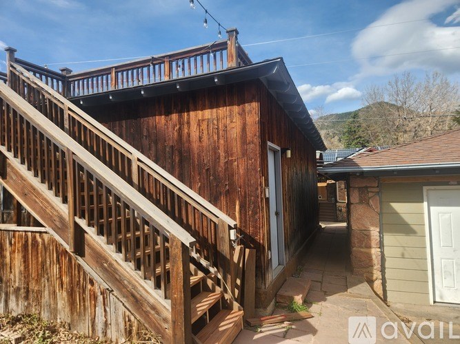 A wooden deck with a staircase leading to a house.