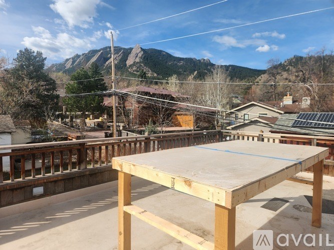 A wooden table is in the foreground of a construction site with a mountain in the background.