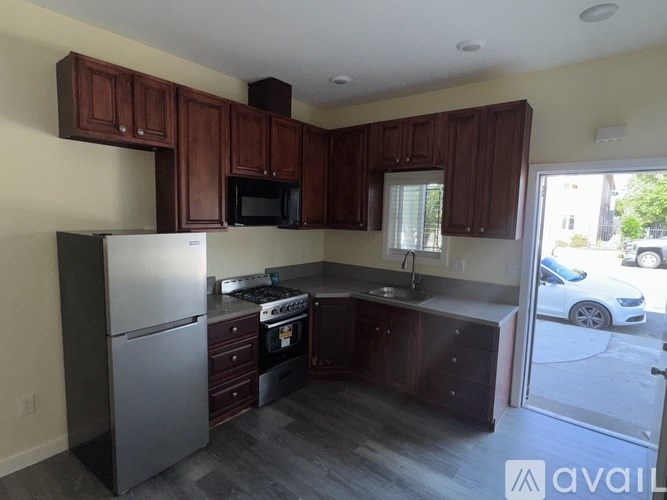 A kitchen with dark wood cabinets and stainless steel appliances.