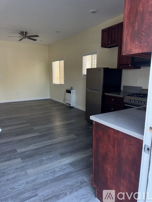 A kitchen with wooden cabinets and a stainless steel refrigerator.