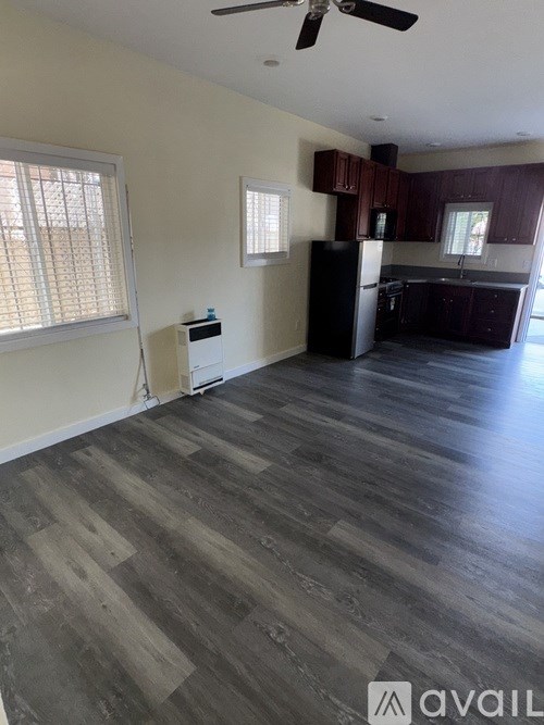 A room with wooden flooring and a ceiling fan.