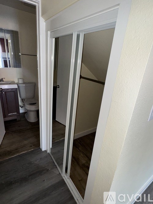 A bathroom with a toilet, sink, and mirror.