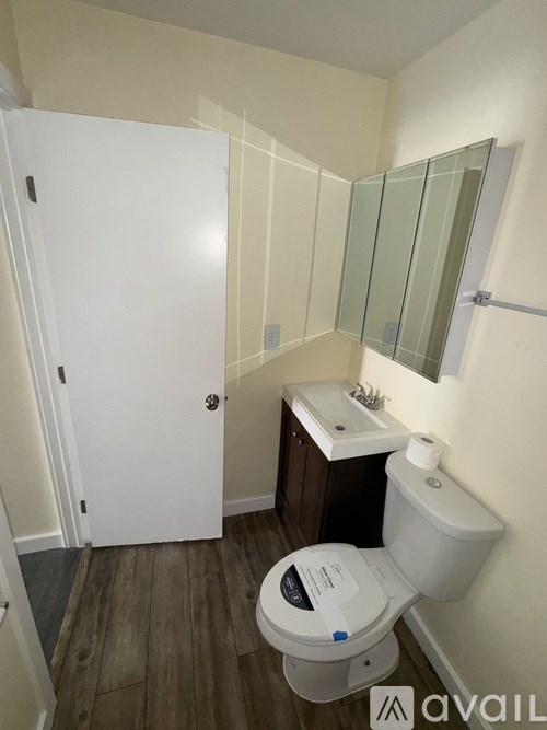 A small bathroom with a toilet, sink and mirror.