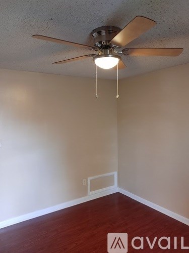 A room with a ceiling fan and light fixture.