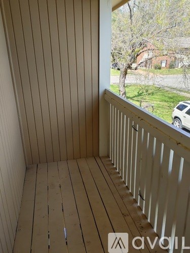 A balcony with a view of a tree and a house.