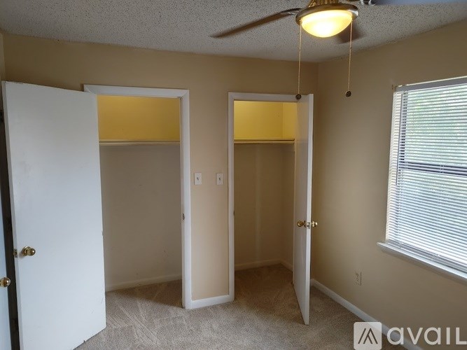 A room with a ceiling fan and two doors.