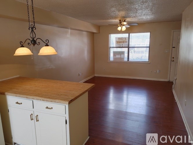 A room with a wooden counter and cabinets is available for rent.