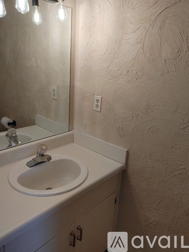 A bathroom with a sink and a mirror.