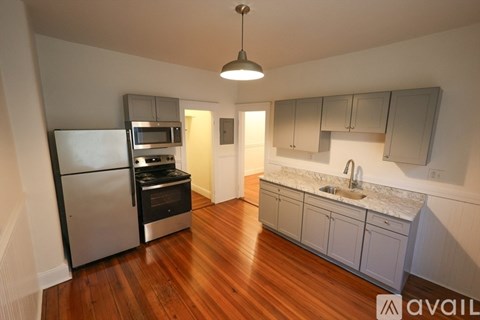 A kitchen with a refrigerator, oven, and sink.