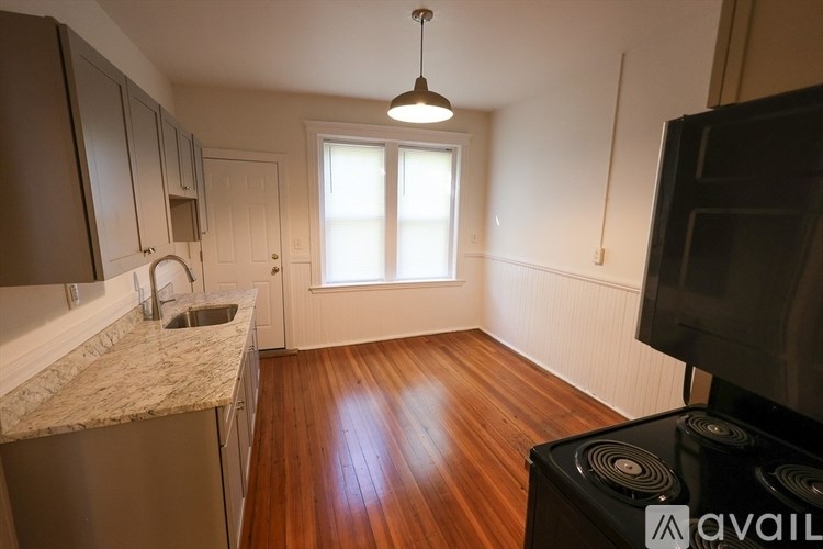 A kitchen with wooden floors and a marble countertop.