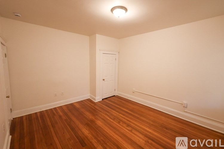 A room with wooden floors and a white door.